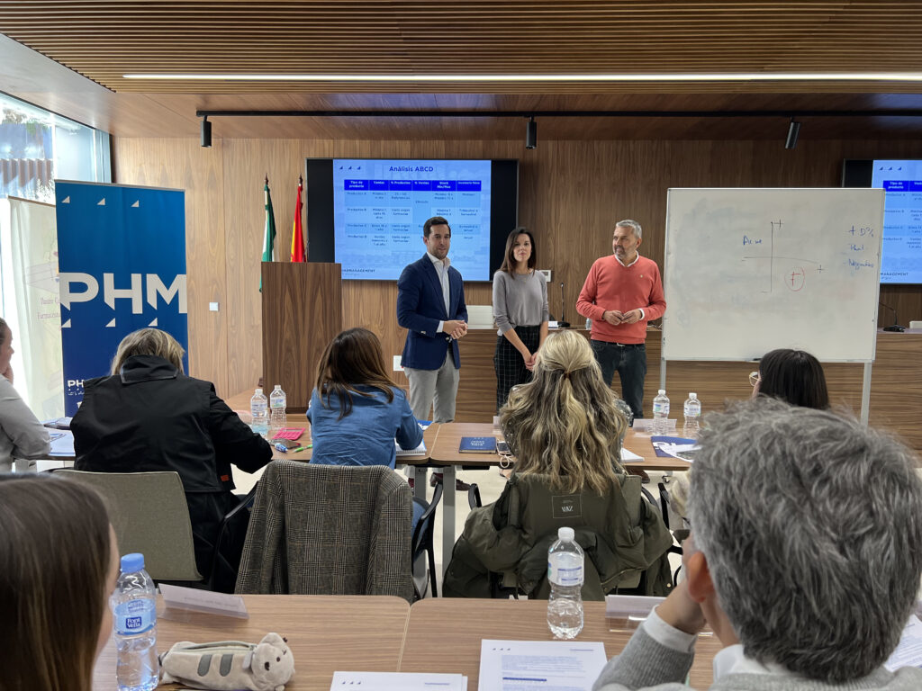 Fran Criado, Presidente del Colegio de Farmacéuticos de Málaga; Tamara Panadero, Secretaria del Colegio; y Pepe Alba, Director Académico de Pharmanagement; visitando a los alumnos en la edición de Málaga